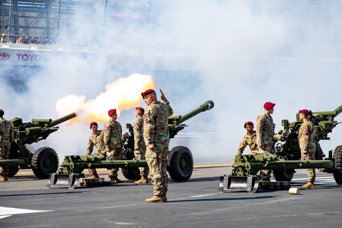 Troops fire their weapons at a race track.