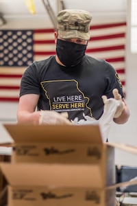 Soldier sorts food into a bag