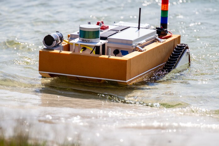 Naval Surface Warfare Center Panama City Division X Department's – “The aXolotls” – amphibious vehicle transitions from water to land at Naval Support Activity Panama City, Fla., during preliminary trials of the Technical Director's Cup, May 17, 2022. They chose to build an amphibious vehicle capable of autonomous navigation both on land and at sea, quickly transitioning between the two, according to X Department Team Captain Melanie MacBain. (U.S. Navy photo by Bob Lindee)