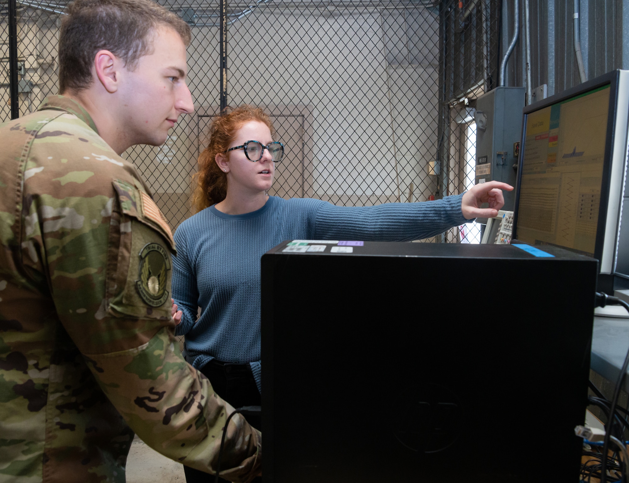 AEDC team members Nicole Prieto and 2nd Lt. Paul McCormack, both with the 717 Test Squadron, look at data from a non-interference stress measurement system training environment in the Innovation Center at Arnold Air Force Base, Tenn., April 27, 2022.