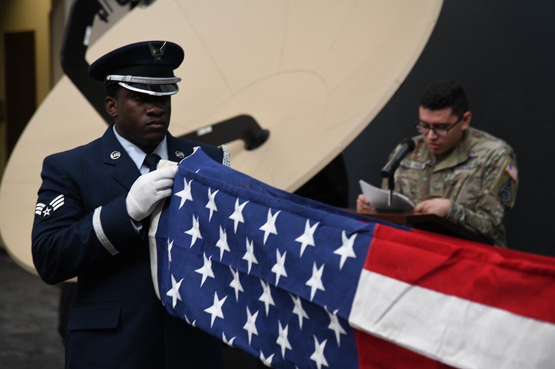 U.S. Air Force Senior Airman Brandon Whittaker, High Frontier Ceremonial Guardsman, folds an American flag during a Space Delta 3 – Space Electromagnetic Warfare pre-deployment-flag-folding ceremony at Peterson Space Force Base, Colorado, 2022. Flags folded at these ceremonies are flown during deployment by members from DEL 3. DEL 3’s ceremonial tradition of folding flags to bring on deployment, dates back over 20 years to the 76th Space Control Squadron. (U.S. Space Force Photo by Airman 1st Class Aaron Edwards)
