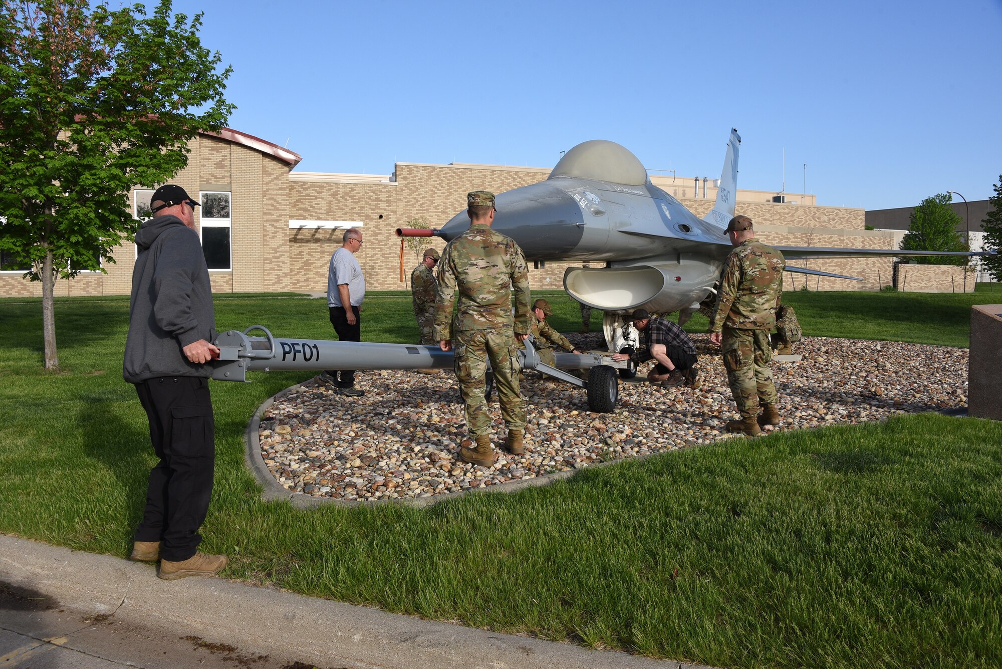 A U.S. Air Force F-16 is removed from static display and moved to paint facility.