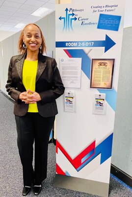 Female standing next to informational graphic.