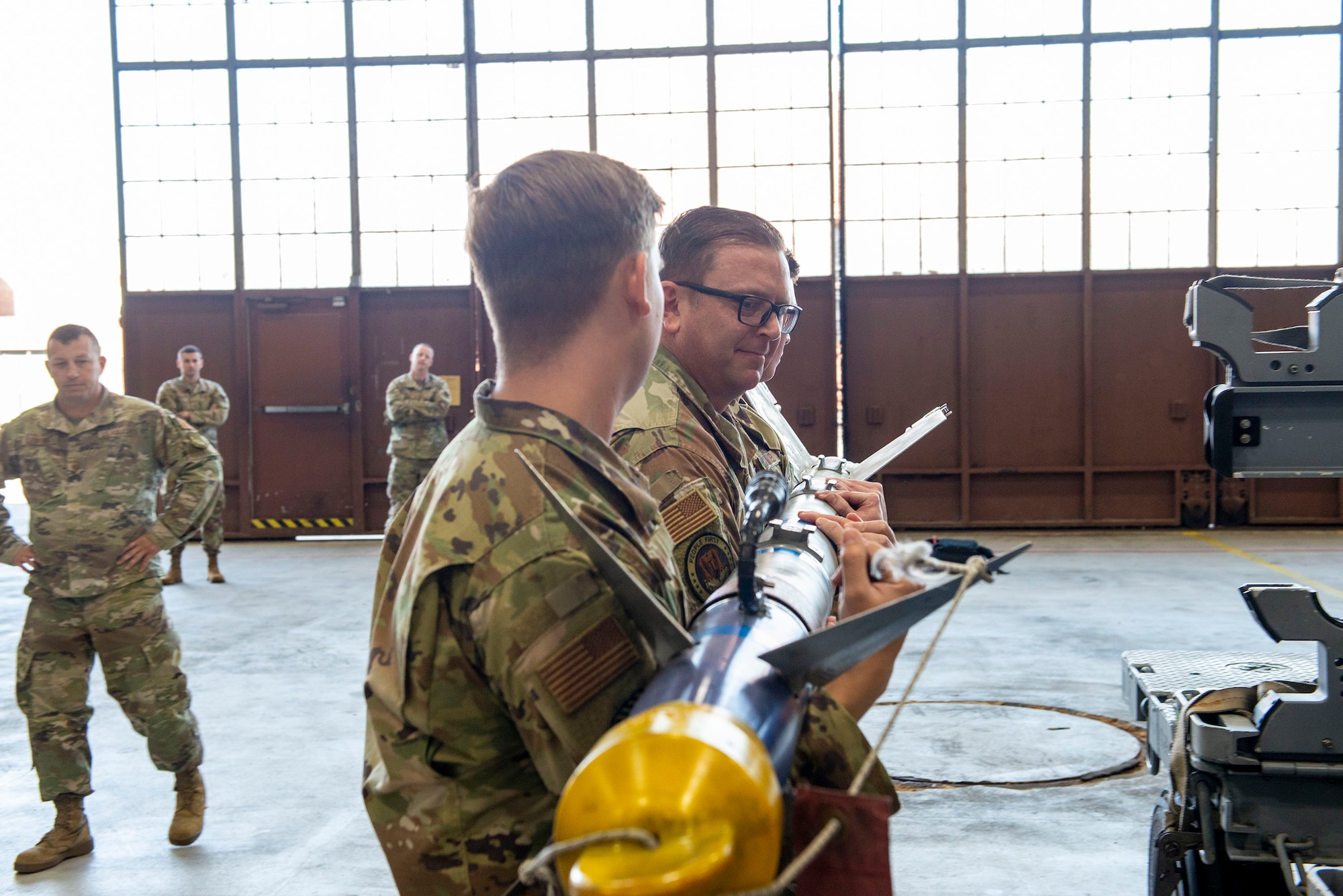 Airmen pick up a munition.