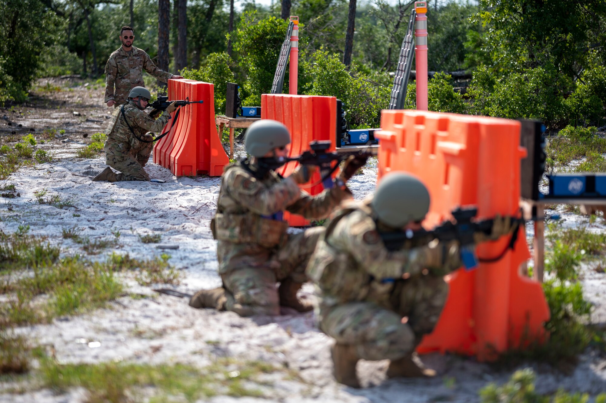 Airmen take cover behind a barrier
