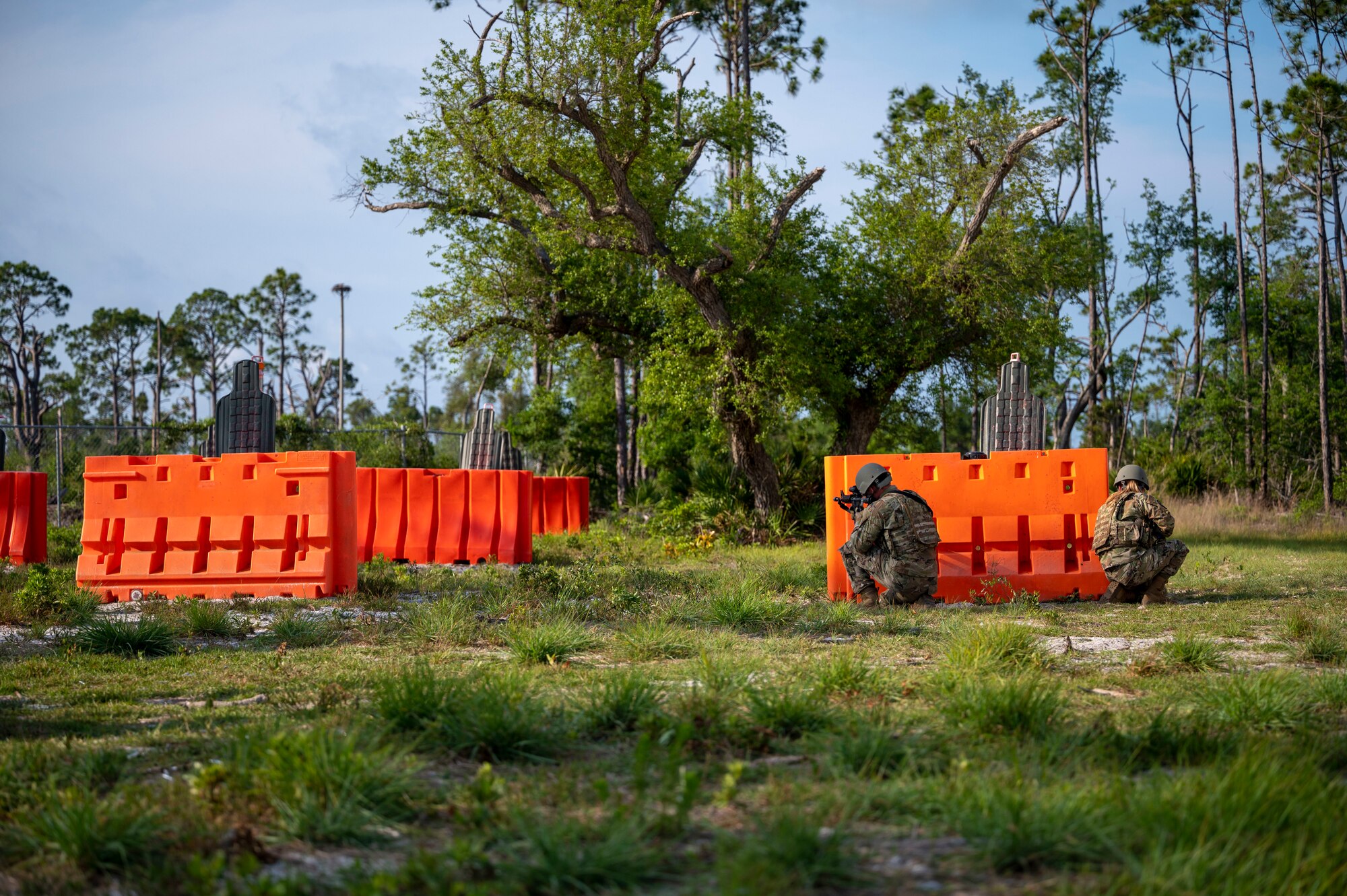 Airmen sit behind a barrier