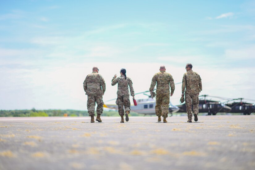 Joint Base Andrews leaders and a U.S. Army escort  walk to a  Bell UH-1N “ Huey” to depart Fort Indiantown Gap, Pa., May 25, 2022.