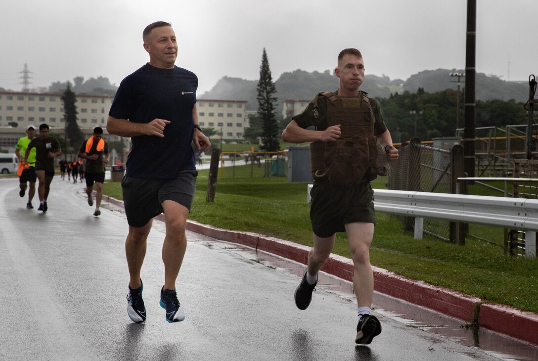 U.S. Marine Corps Col. David M. Banning, left, commanding officer of Headquarters and Support Battalion, Marine Corps Base Camp Butler, Marine Corps Installation Pacific, runs alongside Lance Cpl. Christopher Lape, a combat videographer with Communications Strategy and Operations, 31st Marine Expeditionary Unit during the Memorial Day 5k Fun Run at Gunner's Gym, Camp Foster, Okinawa, Japan, on May 28, 2022. The Memorial Day 5k Fun Run is an annual event held by Marine Corps Community Services to honor fallen U.S. service members in the line of duty. (U.S. Marine Corps photo by Cpl. Isaac W Munce)