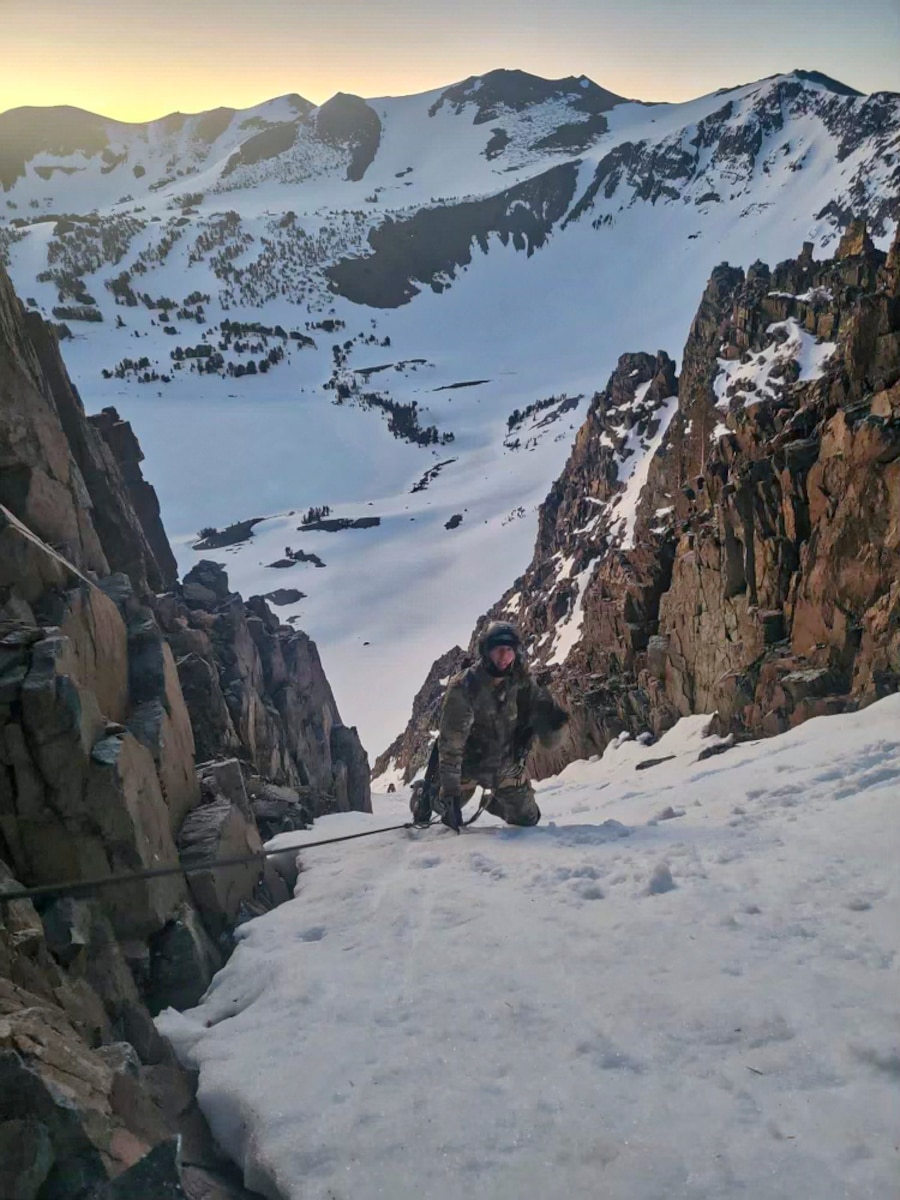 A photo of an Airman climbing up a snowy mountainside.