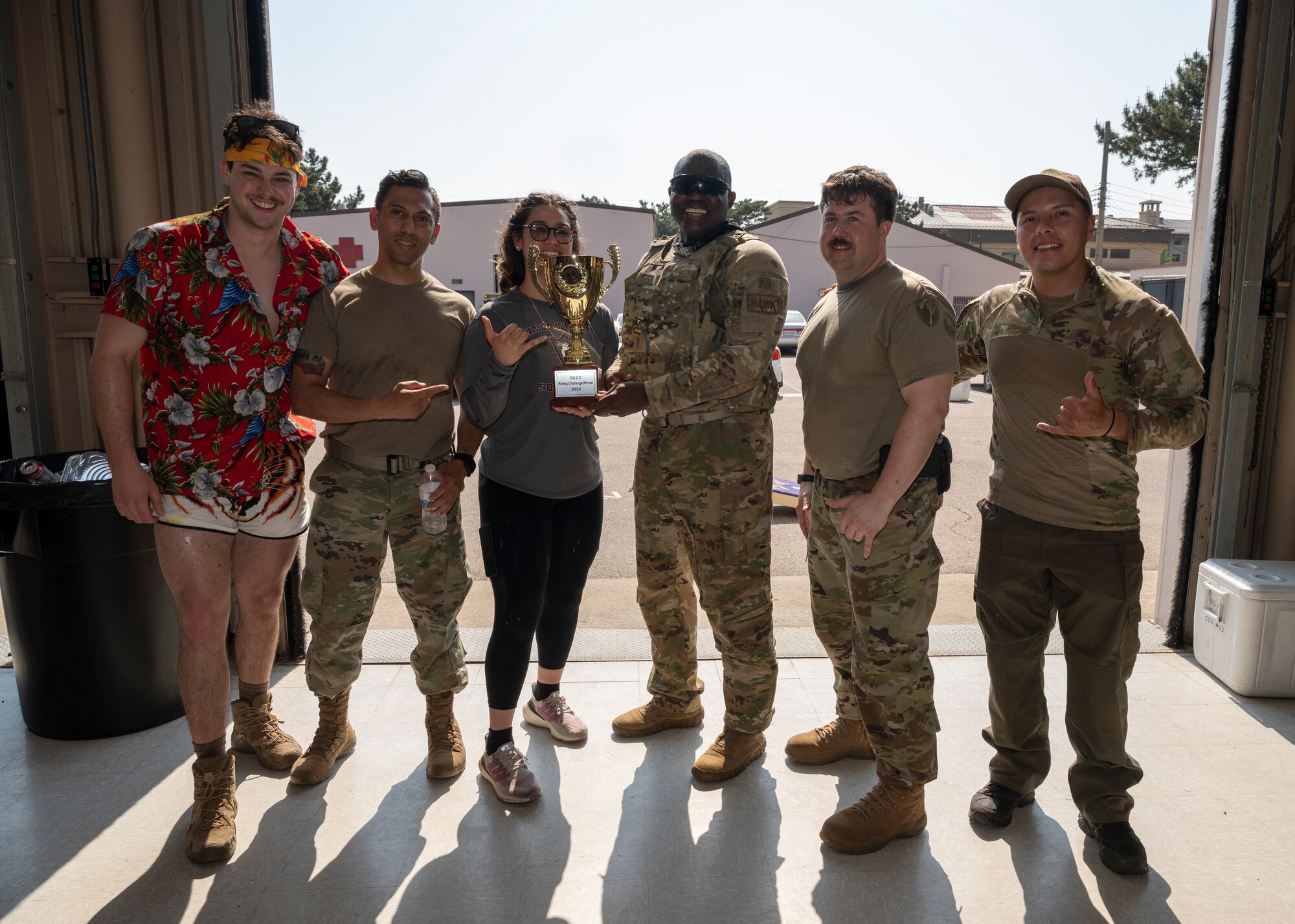 A group of Airmen pose for a photo with trophy.