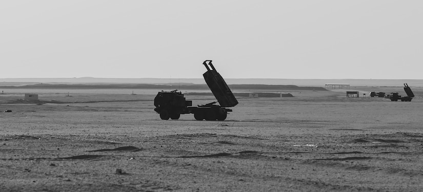 An weapons system sits in a desert environment.