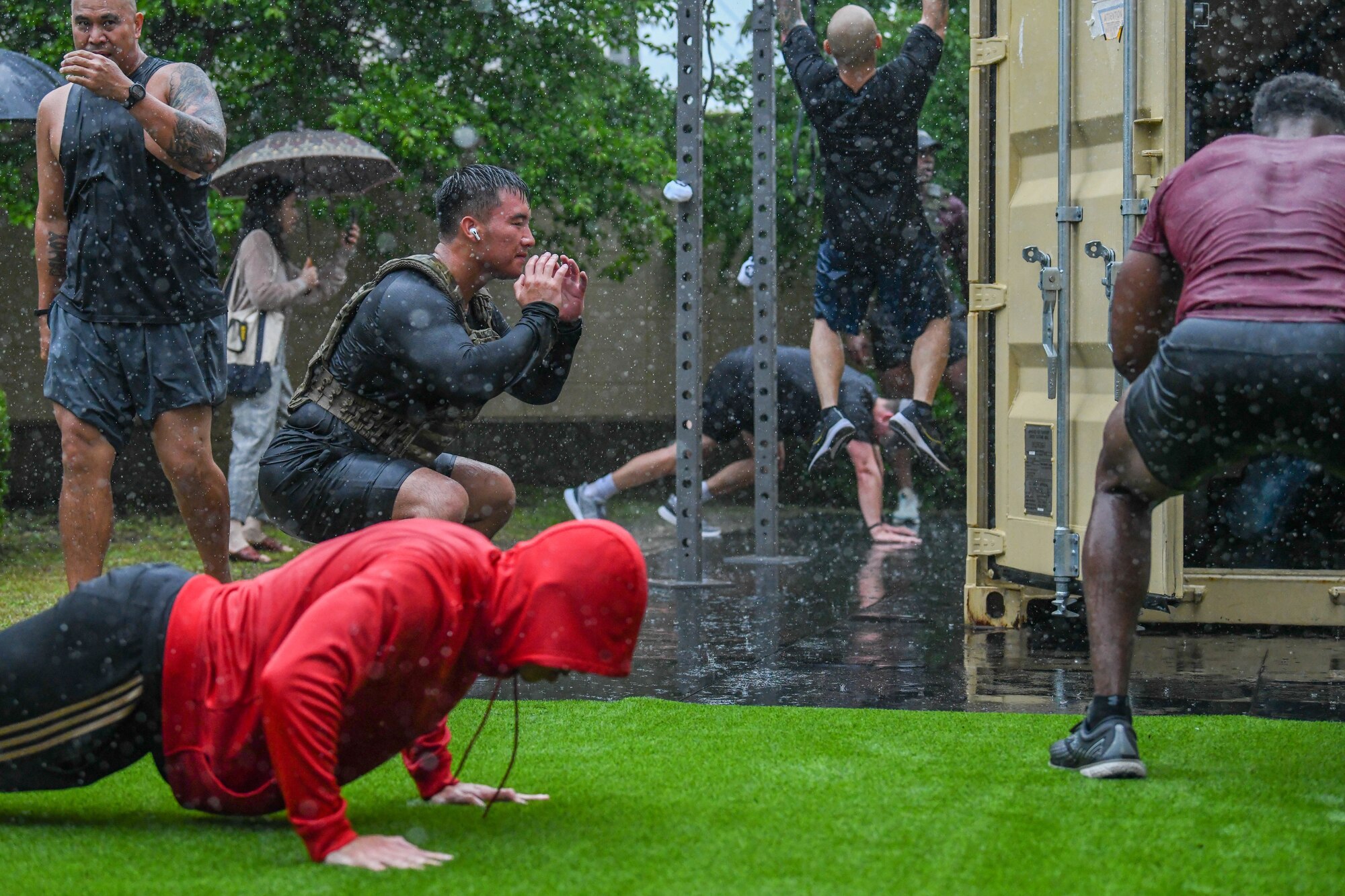Fitness enthusiasts perform squats, pull-ups and push-ups during a Murph challenge at Yokota Air Base, Japan, May 27, 2022. The Murph challenge coincided with a box gym grand opening at the base natatorium. (U.S. Air Force photo by Staff Sgt. Jessica Avallone)