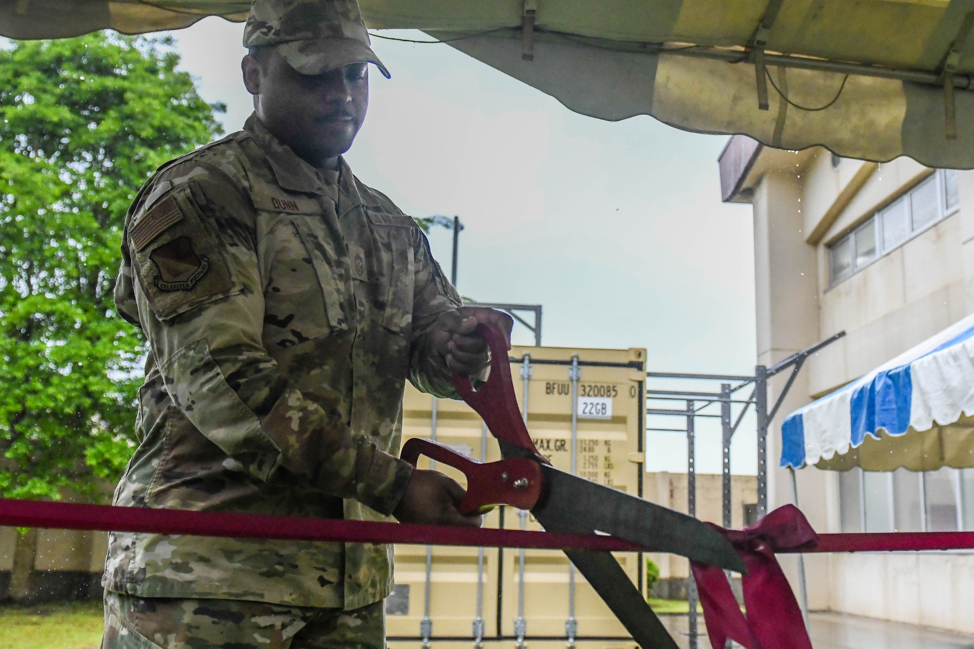 Chief Master Sgt. Jerry Dunn, 374th Airlift Wing command chief, cuts a ribbon, for a new box gym at Yokota Air Base, Japan, May 27, 2022. The U.S. Olympic & Paralympic Committee donated a high-performance box gym to Yokota Air Base during the 2020 Olympic games. (U.S. Air Force photo by Staff Sgt. Jessica Avallone)