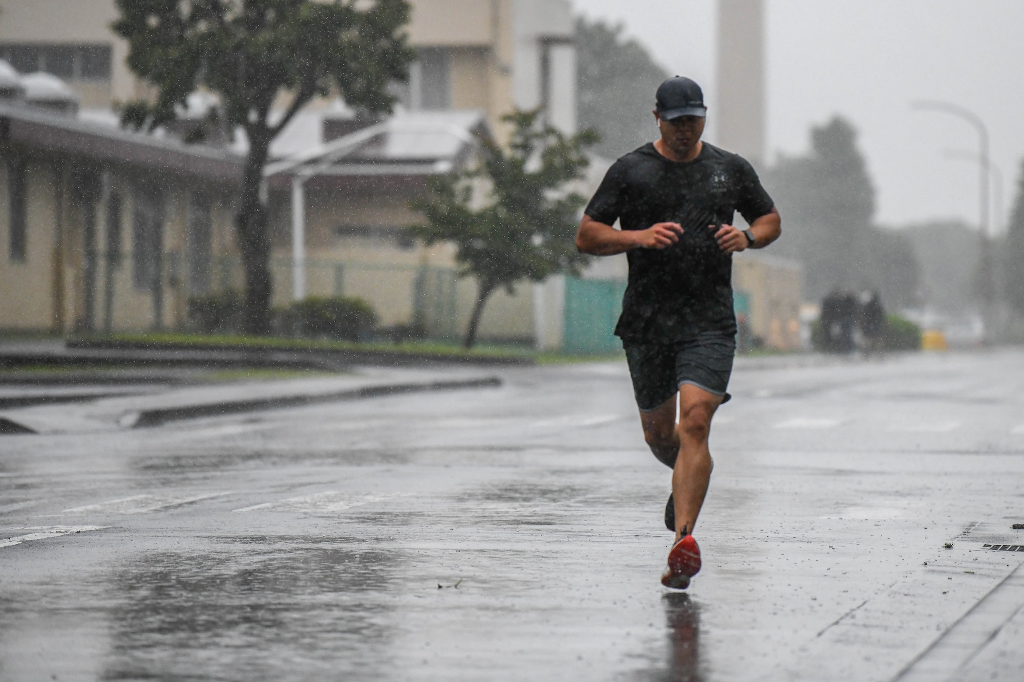 Master Sgt. Arnulfo “Jay” Valdez, 374th Force Support Squadron fitness and sports superintendent, runs his first mile of the Murph challenge in the rain, at Yokota Air Base, Japan, May 27, 2022. The challenge coincided with a box gym grand opening at the base natatorium. (U.S. Air Force photo by Staff Sgt. Jessica Avallone)