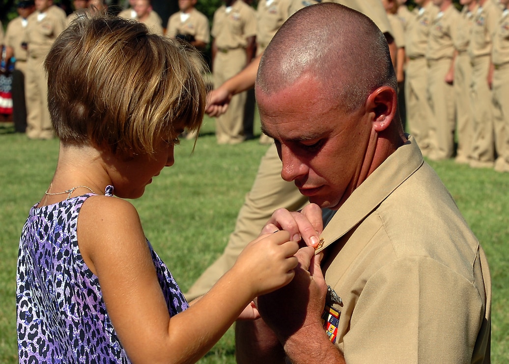 A chief petty officer receives his anchors from his family during the chief petty officer pinning ceremony at the Washington Navy Yard.