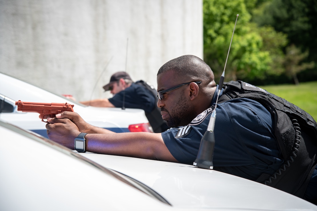 Naval District Washington security forces officers aims imitation firearms during an anti-terrorism training exercise onboard Naval Support Facility Carderock.