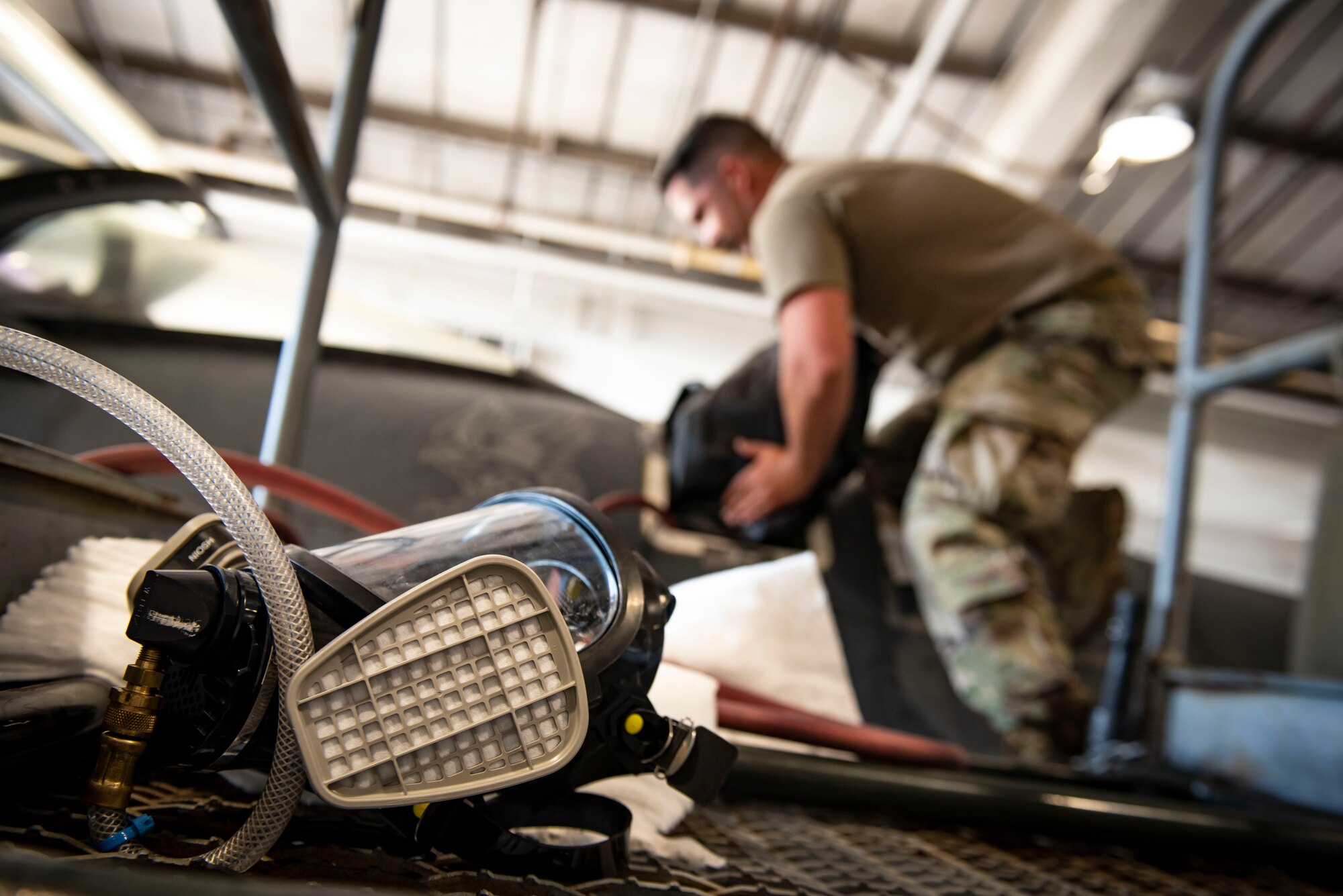 An Airman places an F1 fuel cell into a fuel tank.