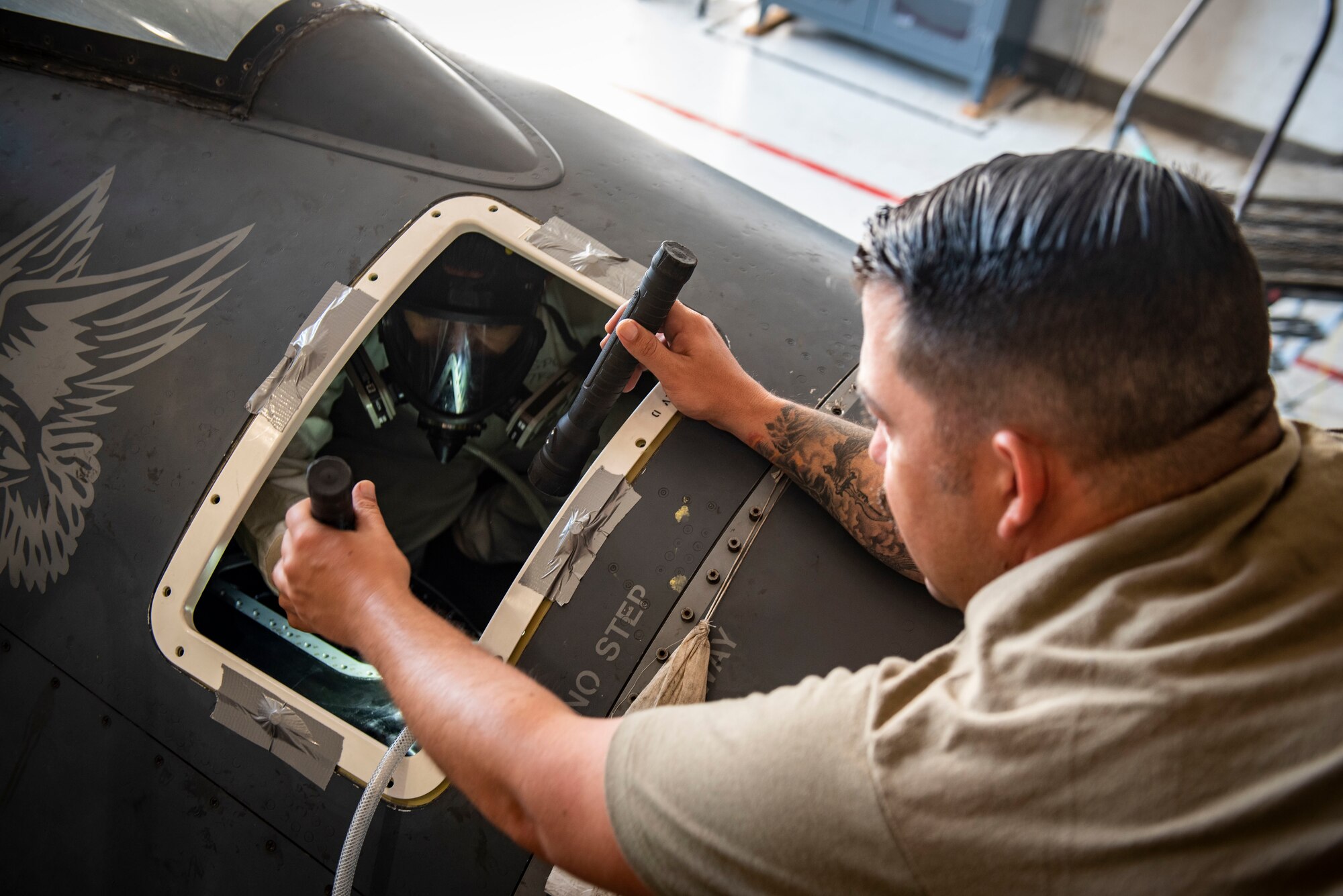 An Airman assists another Airman during an F1 fuel cell replacement.