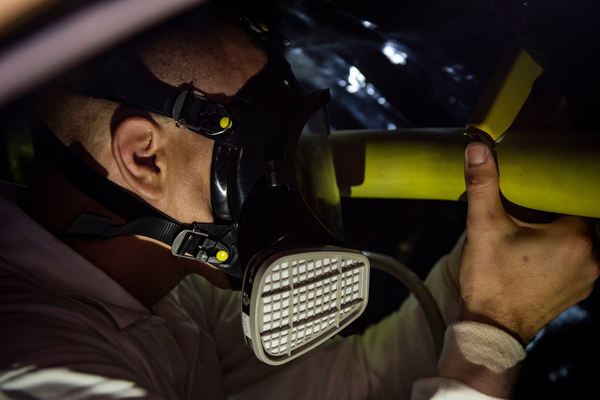 An Airman attaches a manifold.