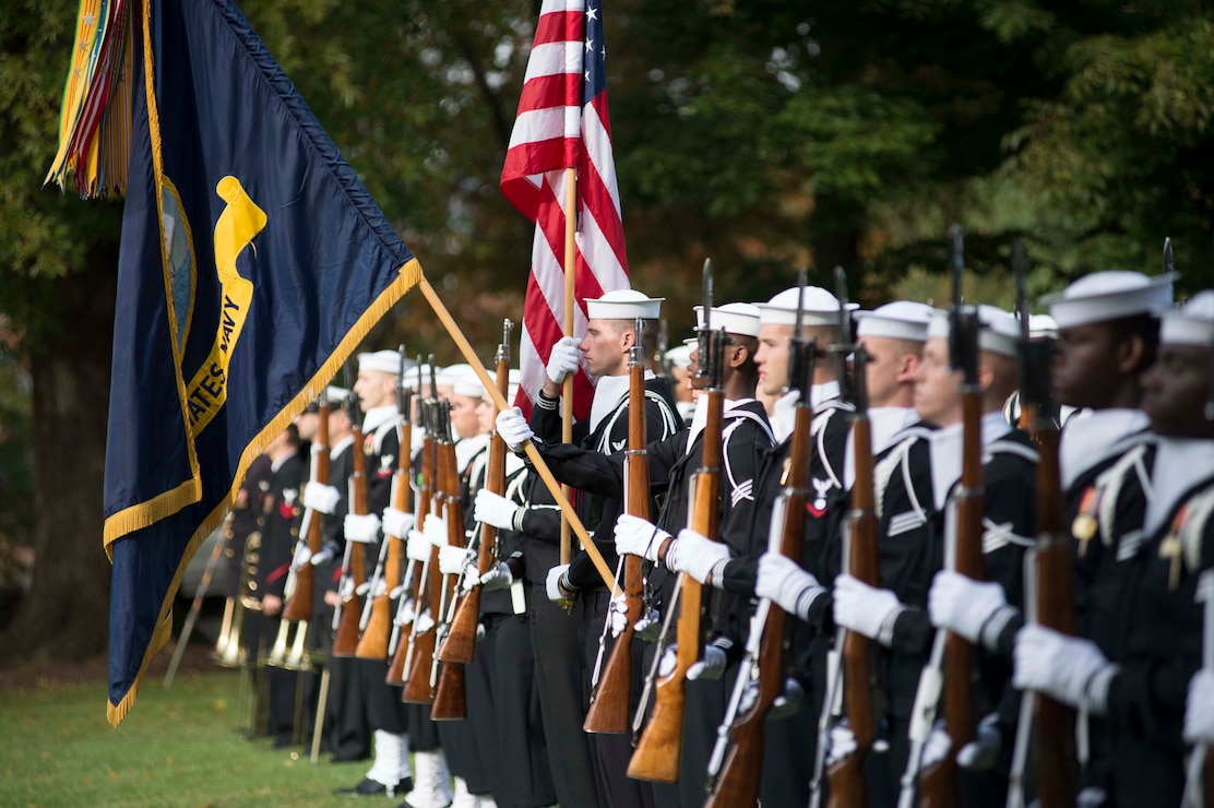 Sailors in the U.S. Navy Ceremonial Guard present the colors during the  national anthem in Leutze Park at the Washington Navy Yard during a full honors ceremony at the Commander, Navy Installations Command (CNIC) change of command ceremony.