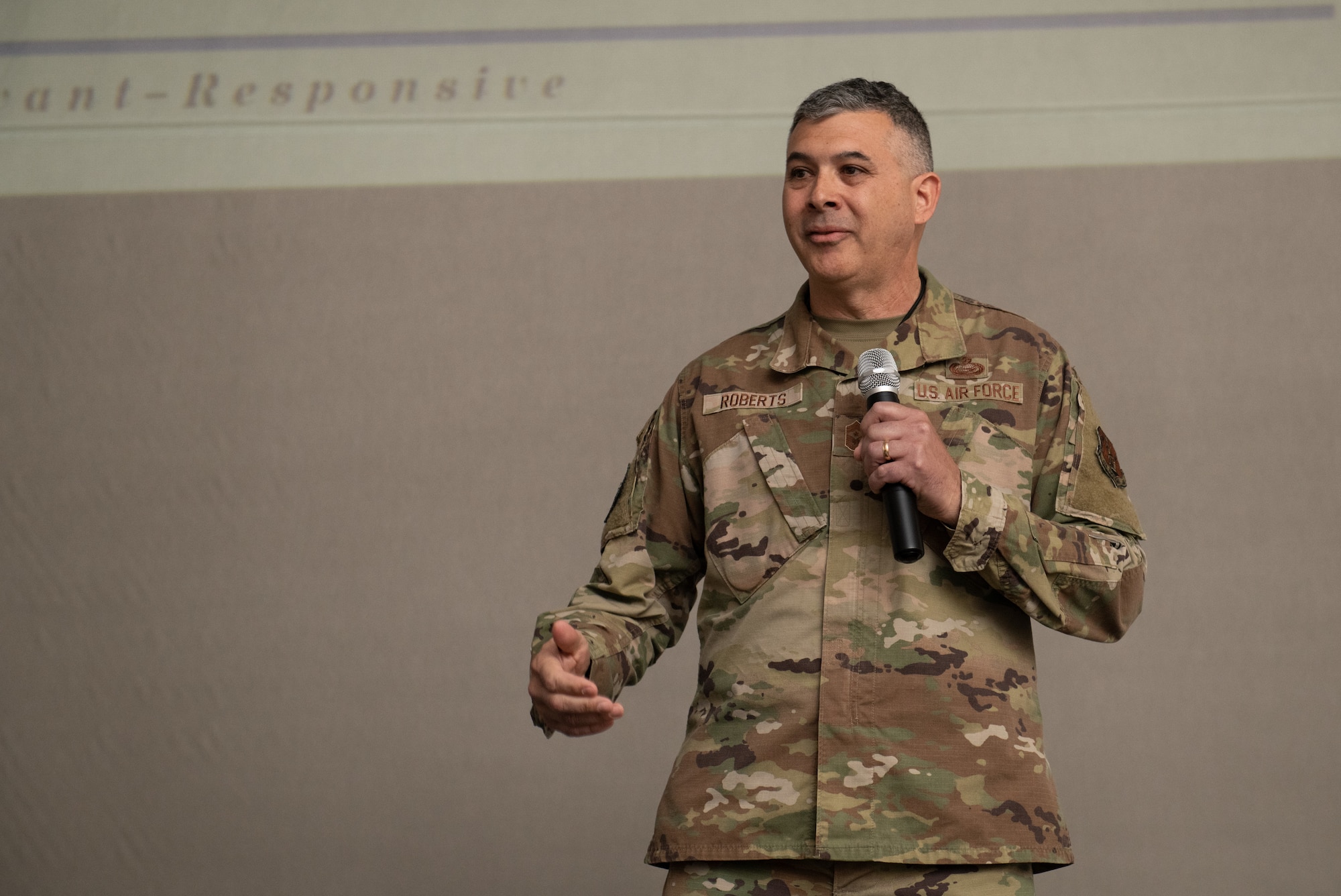 Chief Master Sgt. Richard Roberts, 192nd Wing command chief, speaks on stage.