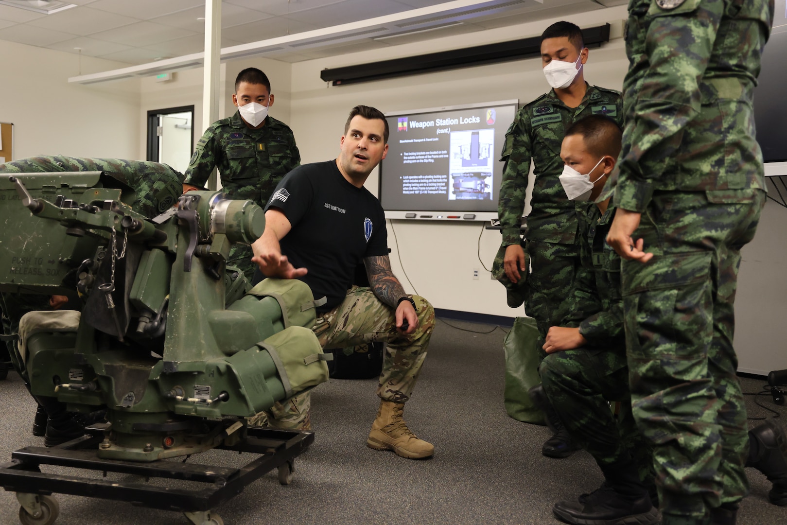 Staff Sgt. Travis Mattoon, Stryker Leaders Course instructor from 1st Battalion, 205th Regional Training Institute, Washington Army National Guard, instructs Royal Thai Army officers on the remote weapons system of a Stryker combat vehicle.