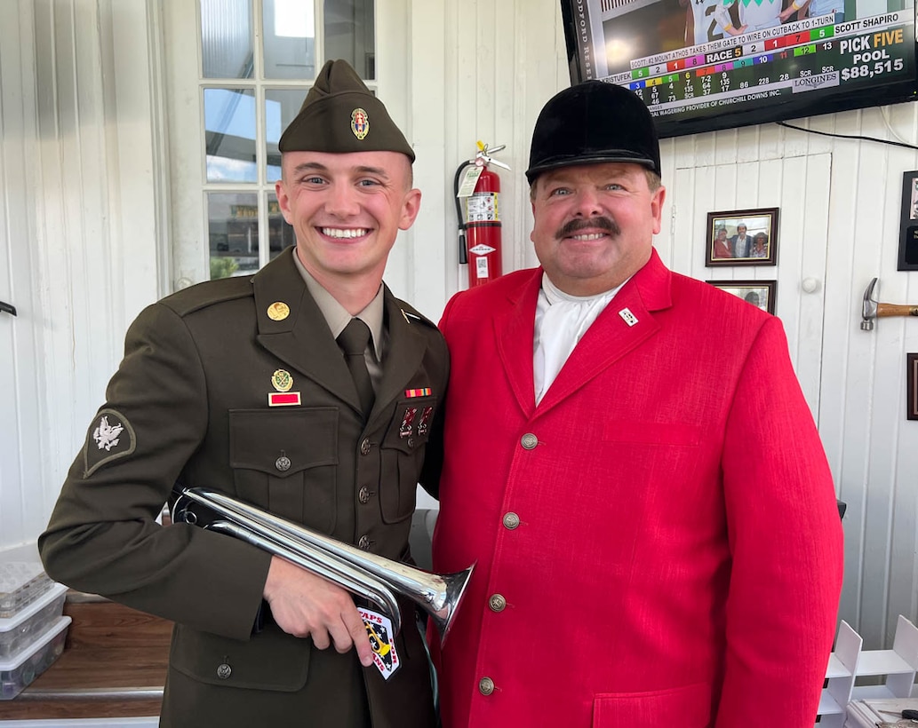 Spc. Anthony Rayburn, 223rd Military Police Company, and Steve Buttleman, the official bugler of Churchill Downs and the Kentucky Derby, play Taps on Memorial Day at Churchill Downs in Louisville, Ky., May 30, 2022. Rayburn was inspired to learn the bugle after Buttleman played for the group of young Boy Scouts in 2010.