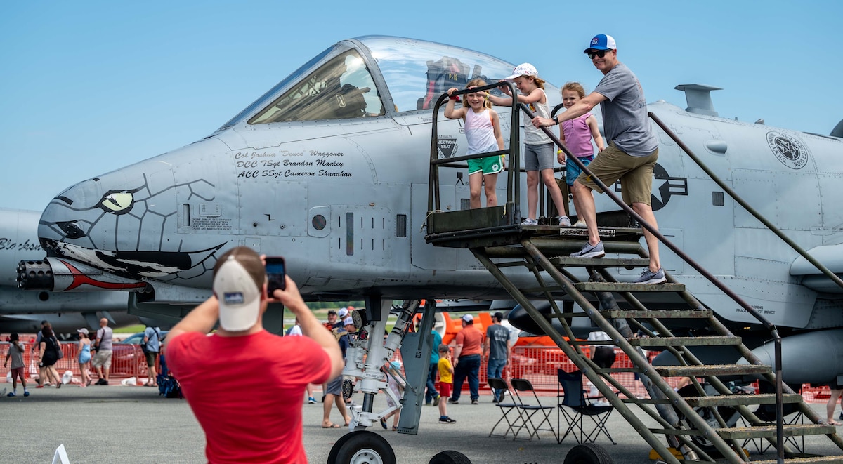 A family poses for a photo near an A-10 Thunderbolt II during the 2022 Thunder Over Dover Airshow, May 22, 2022, at Dover Air Force Base, Delaware. The theme for the airshow, “Reunite,” celebrates the military and the Dover community reuniting for the first time since the COVID-19 pandemic. (U.S. Air Force photo by Senior Airman Faith Schaefer)