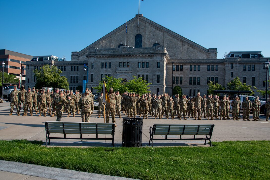 Soldiers stand in formation outside an armory