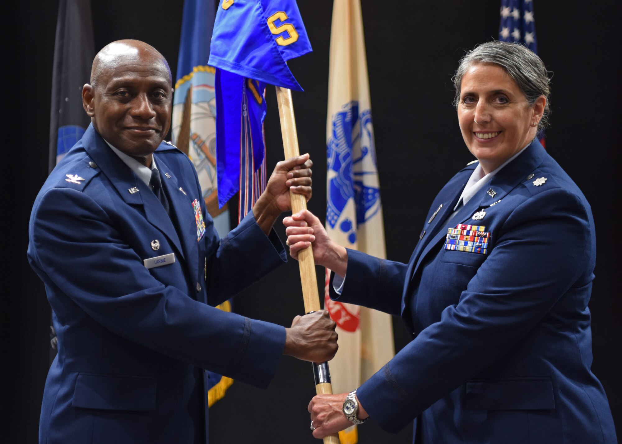 U.S. Air Force Lt. Col. Brenda Miazga, 17th Operational Medical Readiness Squadron incoming commander, (right) assumes command from Col. Derek Larbie, 17th Medical Group commander, during the 17th OMRS change of command ceremony at the Powell Event Center, June 2, 2022. Change of commands are a military tradition representing the transfer of responsibilities from the presiding official to the upcoming official. (U.S. Air Force photo by Senior Airman Ethan Sherwood)