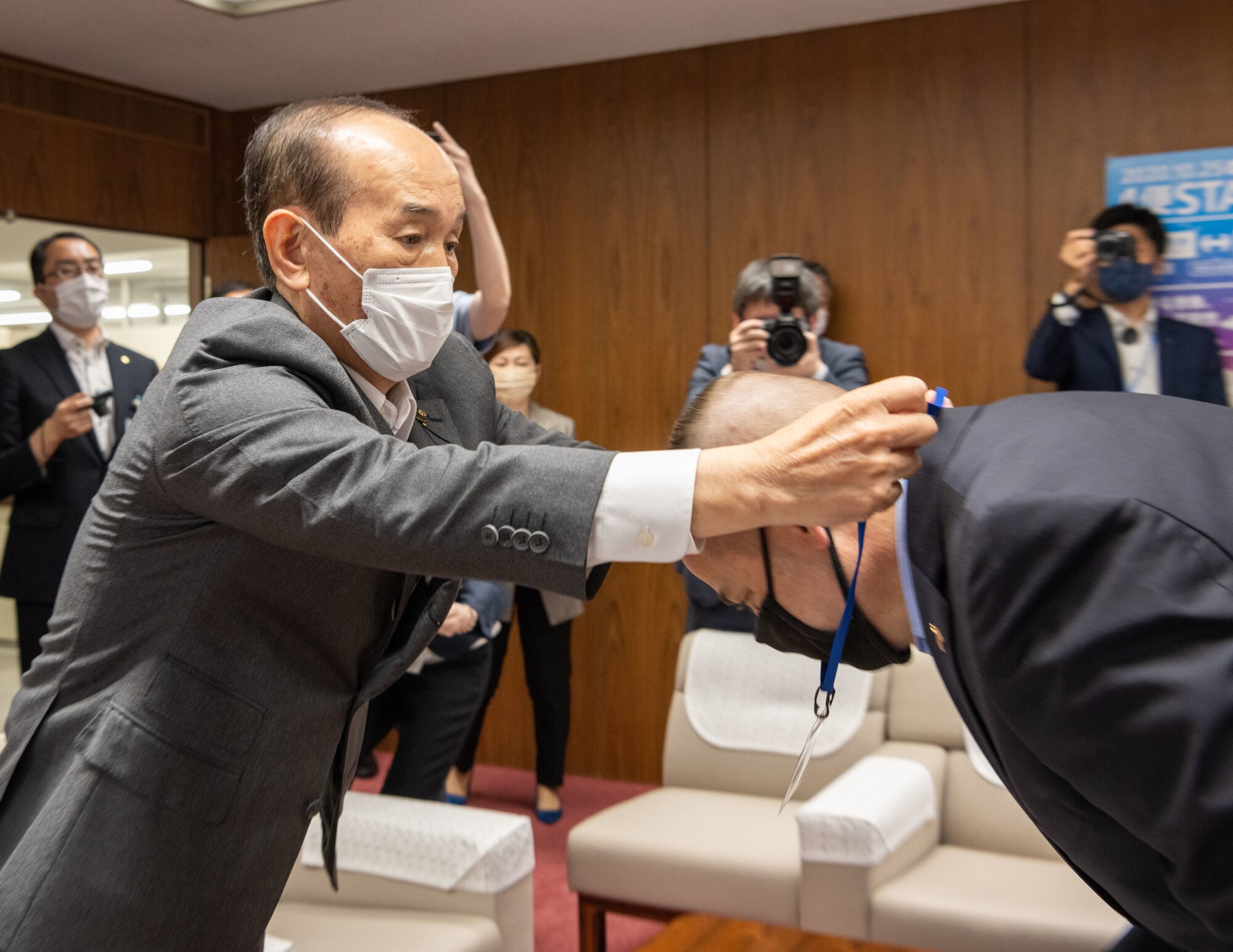 A Japanese government official gives a medal to a military member.
