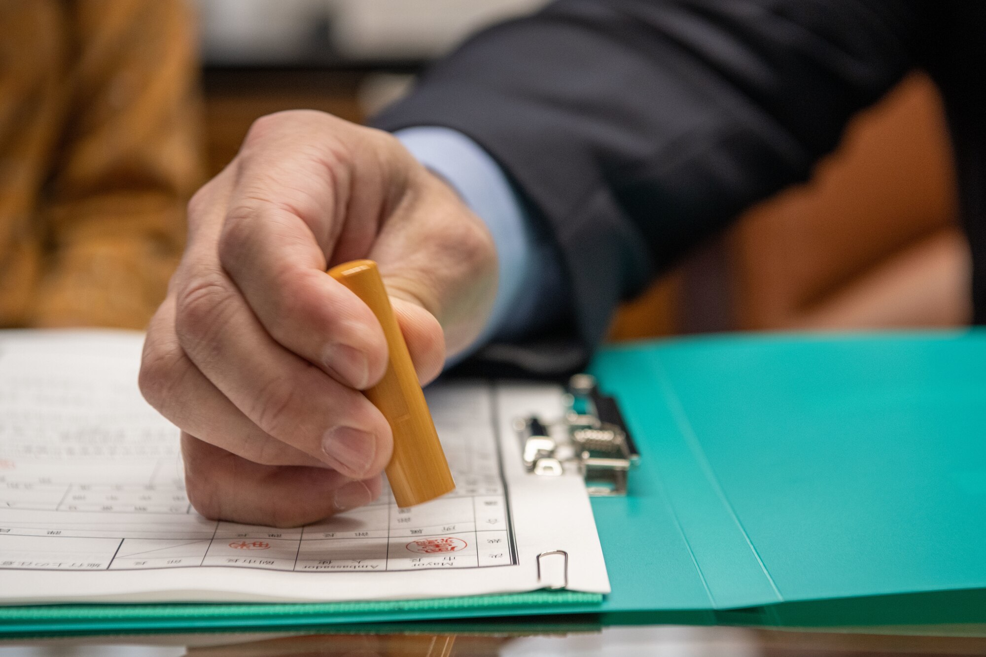 A military member acting as mayor as the day, stamps a document.