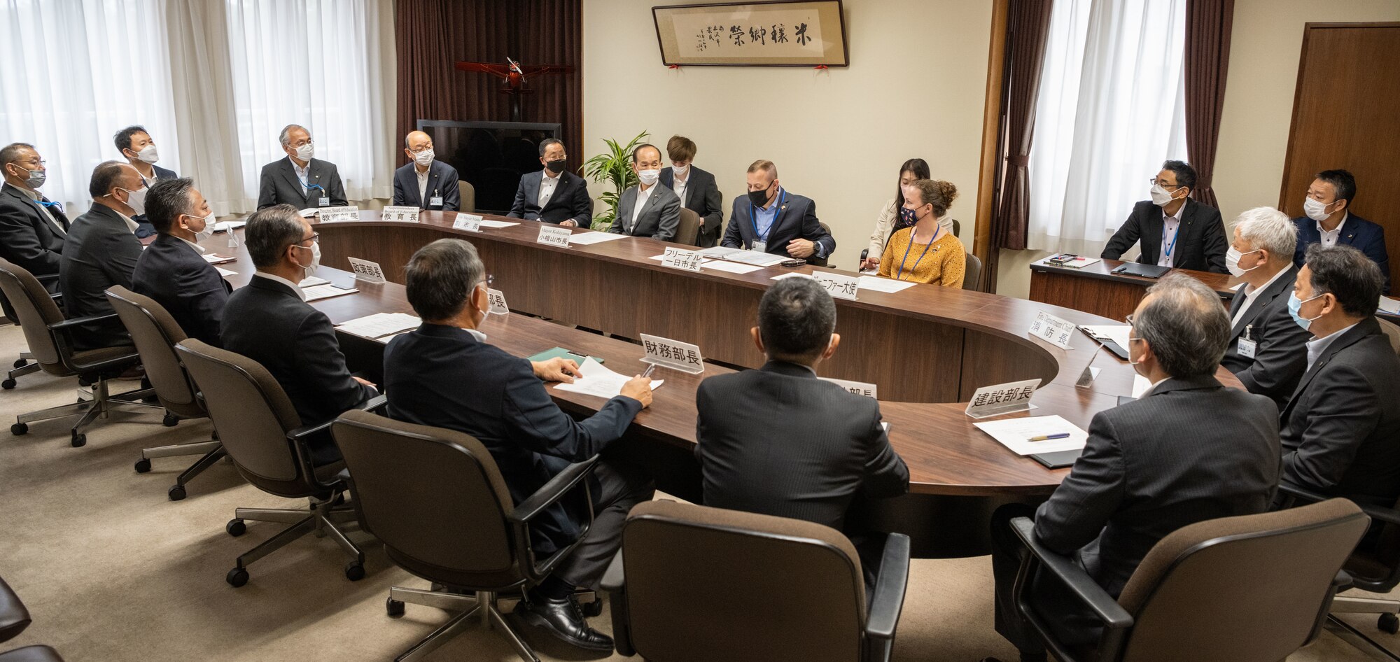 A room full of government officials sit around a table.