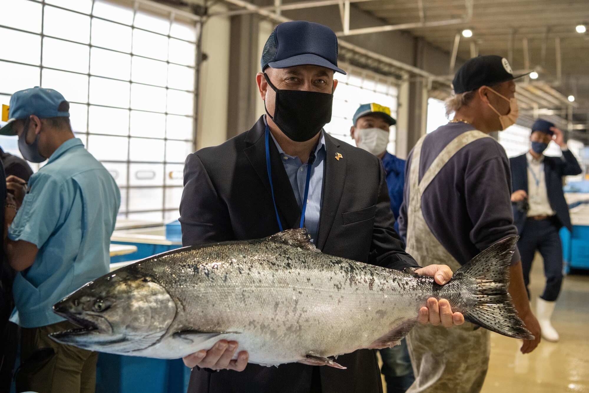 A military member holds a fish.