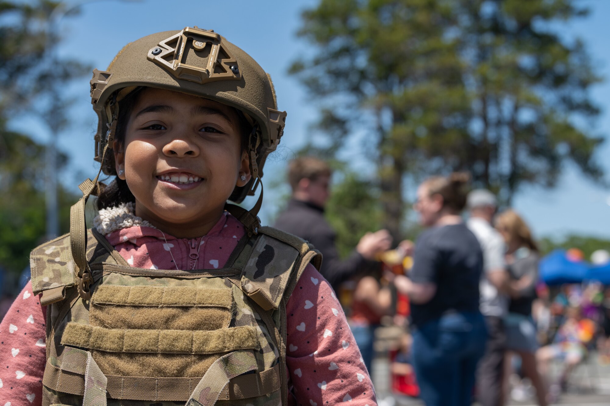 A military child in military body armor stands for a picture.