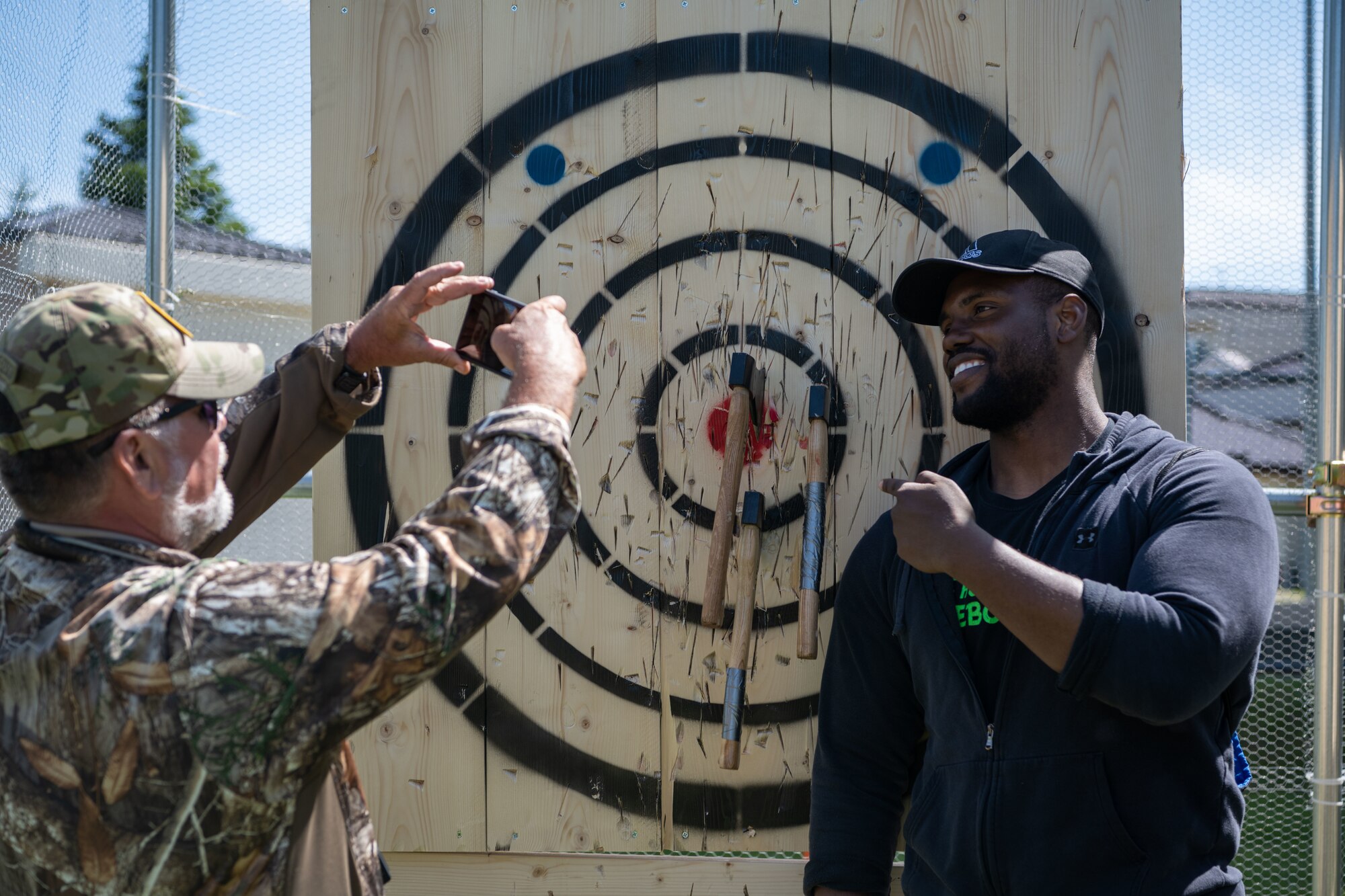 The axe throwing coordinator takes a photo of a Team Misawa member with his bullseye.