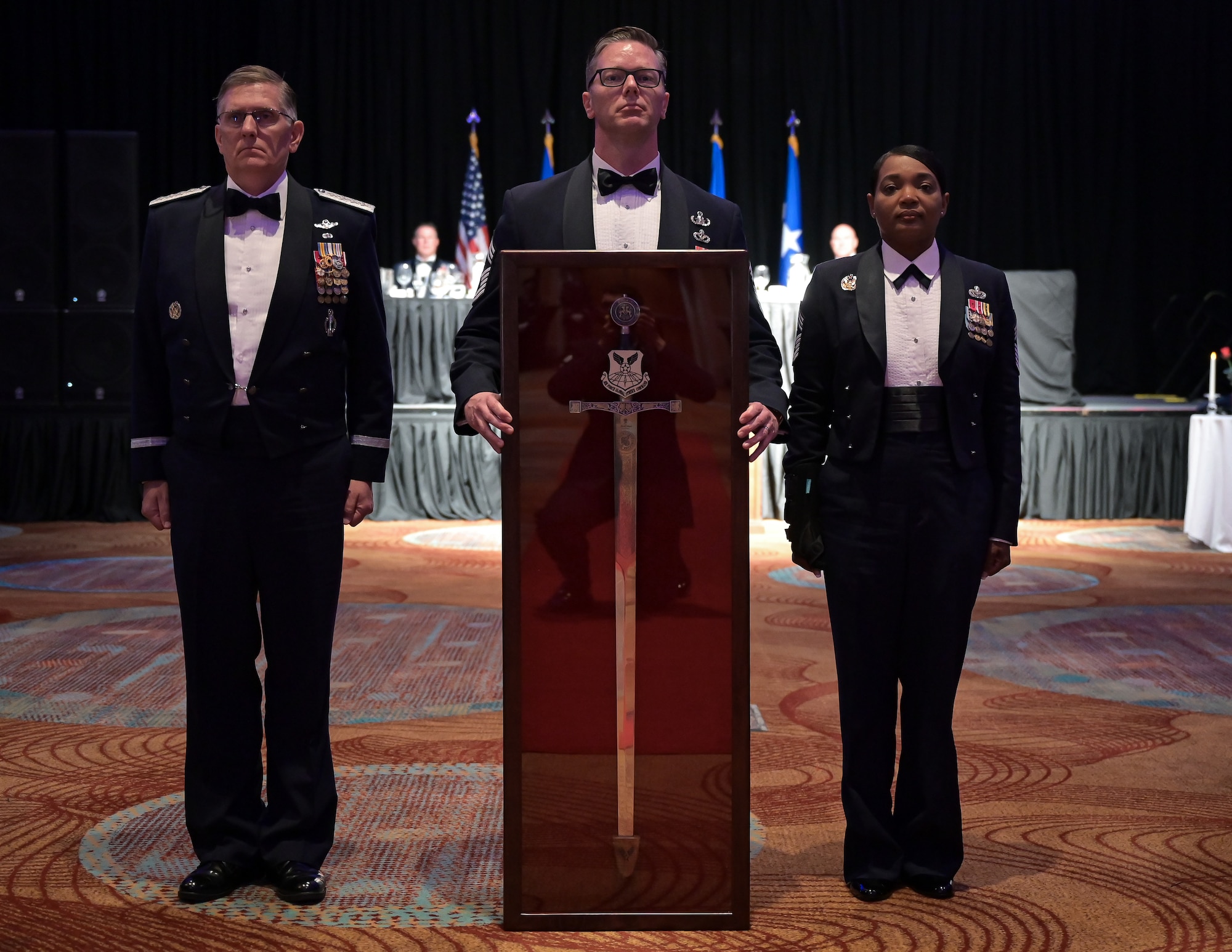 Chief Master Sgt. Melvina Smith, Air Force Global Strike Command command chief, presents the Order of the Sword to Retired Gen. Timothy M. Ray, former AFGSC commander, during his Order of the Sword ceremony at Sam’s Hotel and Casino, Shreveport, Louisiana, May 11, 2022. The ceremonial presentation was adopted from the Royal Order of the Sword and passed to the United States during the Revolutionary War. However, it lay dormant until it was reinstituted in its current form in 1967.  (U.S. Air Force photo by Senior Airman Jonathan E. Ramos)