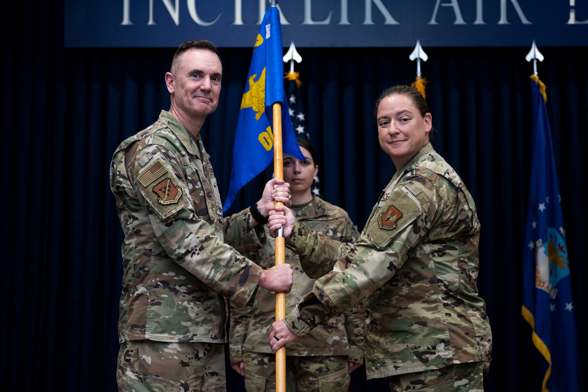 During the ceremony, Col. Christopher Kelly relinquished command to Col. Bradley Weast, 39th Medical Group commander, who then charged Lt. Col. Melissa Tennant with leading the squadron. The change of command ceremony is a long-standing military tradition that represents the formal transfer of responsibility from one officer to another.