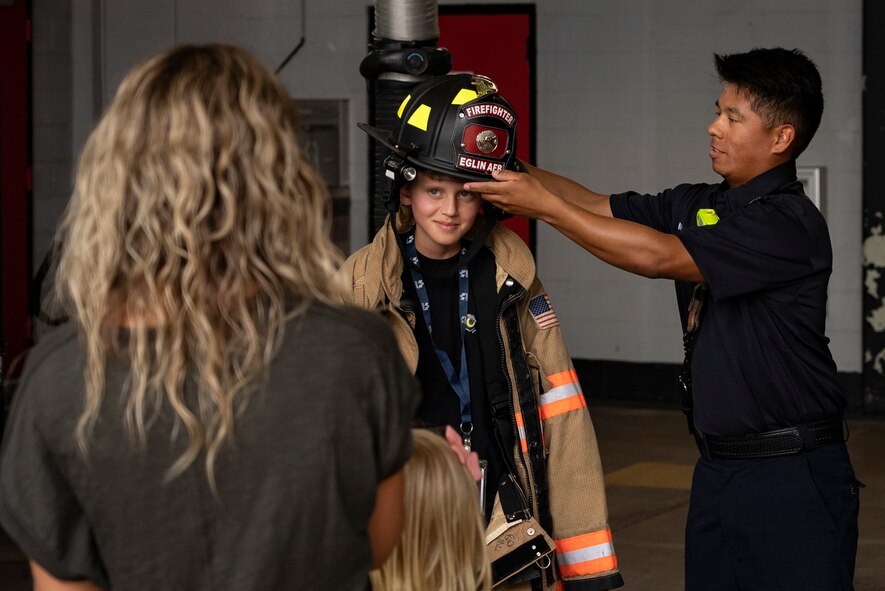 Firefighter places hat on child