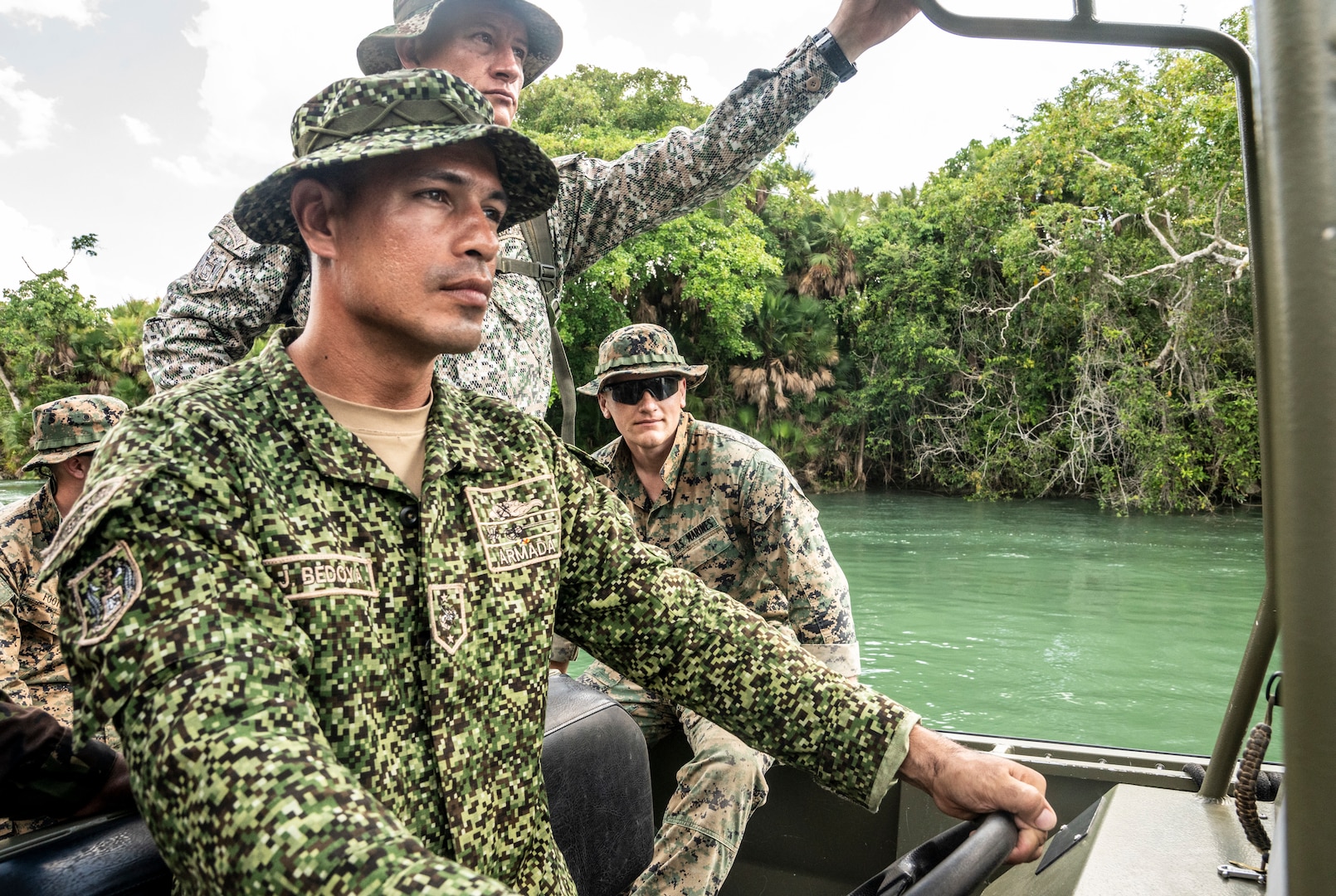 A Colombian Marine alongside U.S. Marines with 3rd Force Reconnaissance company, 4th Marine division, drives a Belizean interdiction vessel during exercise Tradewinds 2022, at Cocoyal outpost, Mexico, May 11, 2022. TW22 is a U.S. Southern Command-sponsored Caribbean-focused multi-dimensional exercise conducted in the ground, air, sea, and cyber domains, designed to provide participating nations opportunities to conduct joint, combined, and interagency training focused on increasing regional cooperation and interoperability in complex multinational security operations.