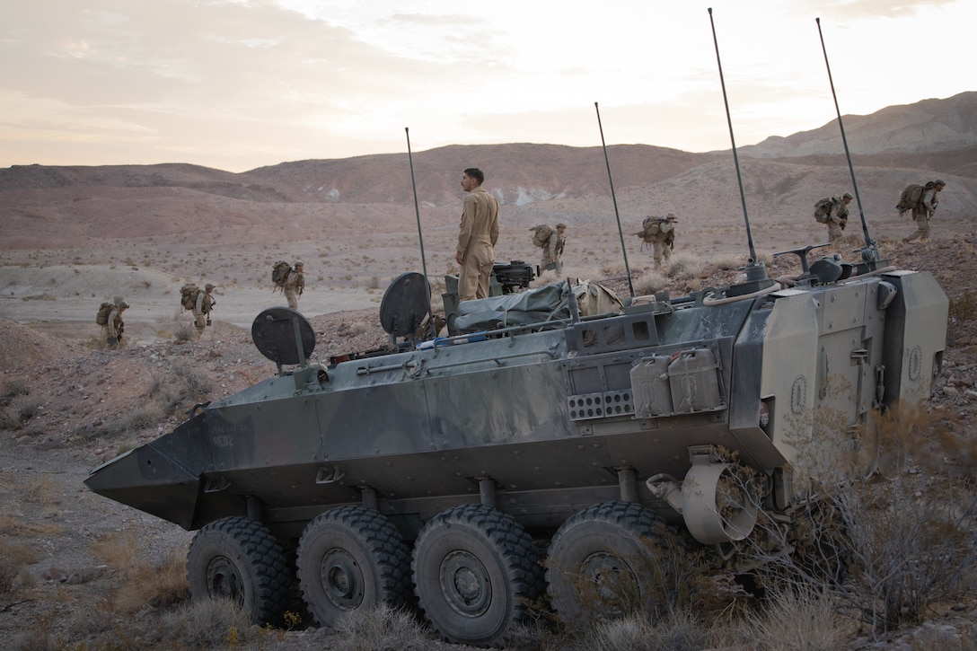 U.S. Marine Corps Cpl. Thomas Nelson, a vehicle commander with Bravo Company, 3d Assault Amphibian Battalion, 1st Marine Division, observes infantrymen moving into a defensive position during Integrated Training Exercise (ITX) 3-22 at Marine Corps Air-Ground Combat Center Twentynine Palms, California, April 26, 2022. ITX is a month-long training evolution comprised of multiple ranges to refine combined arms maneuver in offensive and defensive combat operations. (U.S. Marine Corps photo by Cpl. Jacob Yost)