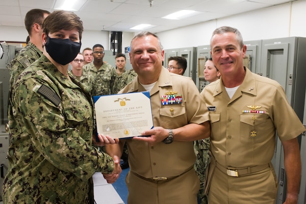 DAHLGREN, Va. (June 01, 2022) Rear Adm. Pete Garvin, commander, Naval Education and Training Command (NETC), and Capt. Russ Sanchez, commanding officer, award Sailor of the Year, Fire Controlman (Aegis) 1st Class Andrea Taylor, with a Navy and Marine Corps Achievement Medal during Garvin’s visit to Surface Combat Systems Training Command (SCSTC) AEGIS Training and Readiness Center (ATRC) onboard Naval Support Facility (NSF) Dahlgren. (U.S. Navy photo by Michael Bova)