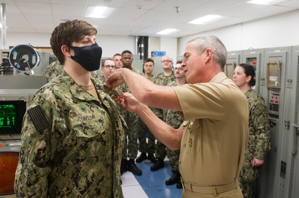DAHLGREN, Va. (June 01, 2022) Rear Adm. Pete Garvin, commander, Naval Education and Training Command (NETC), pins a Navy and Marine Corps Achievement Medal on Sailor of the Year, Fire Controlman (Aegis) 1st Class Andrea Taylor, during his visit to Surface Combat Systems Training Command (SCSTC) AEGIS Training and Readiness Center (ATRC) onboard Naval Support Facility (NSF) Dahlgren. (U.S. Navy photo by Michael Bova)