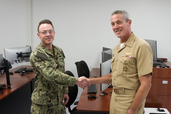 (June 01, 2022) Rear Adm. Pete Garvin, commander, Naval Education and Training Command (NETC), recognizes Sailor of the Quarter Fire Controlman (Aegis) 1st Class Dustin Stephens’ achievements during his visit to Surface Combat Systems Training Command (SCSTC) AEGIS Training and Readiness Center (ATRC) onboard Naval Support Facility (NSF) Dahlgren. (U.S. Navy photo by Michael Bova)