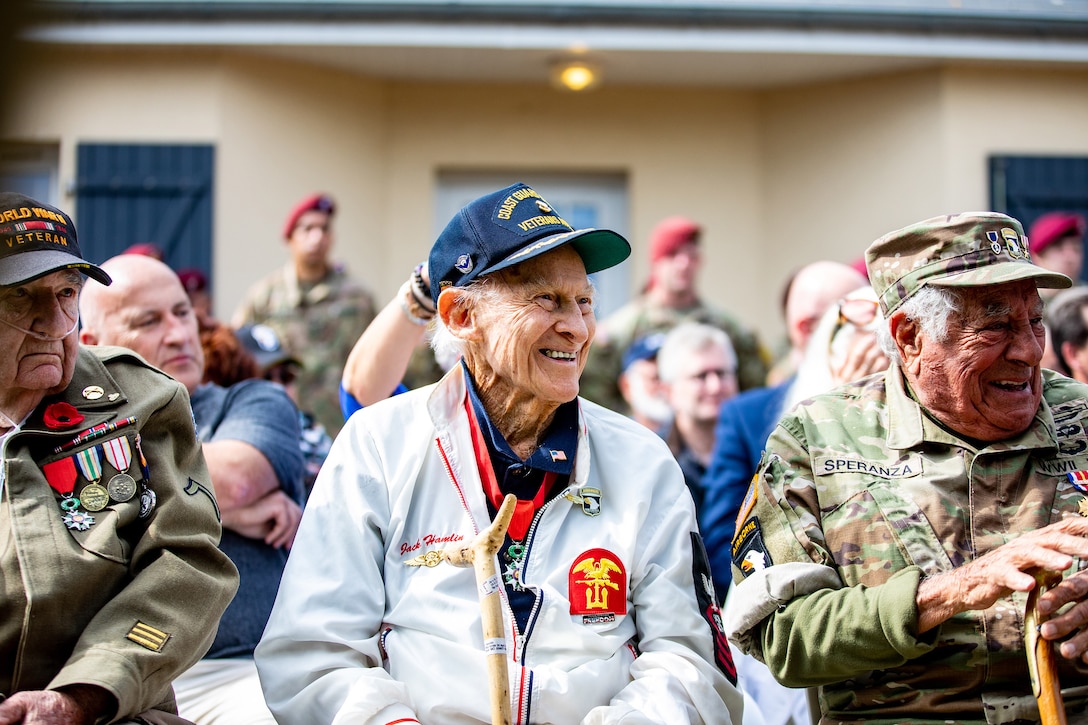Veterans in a seated audience smile.