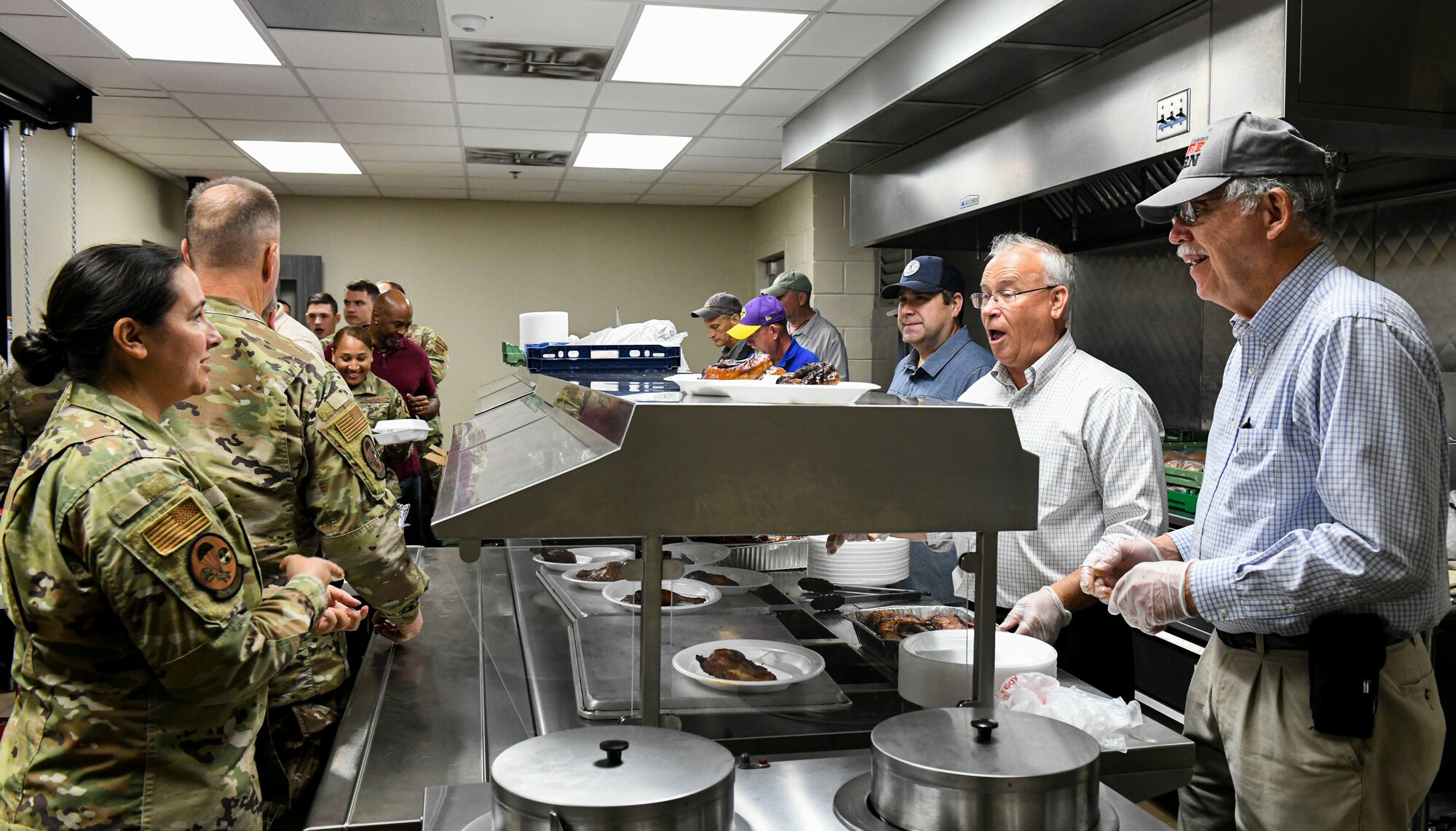 Former and present commanders and command chief master sergeants of the 172nd Airlift Wing gathered to serve lunch to Airmen and full-time staff at the Wing’s dining facility on April 6, 2022. (U.S. Air National Guard photo by 1st Lt. Kiara Spann)