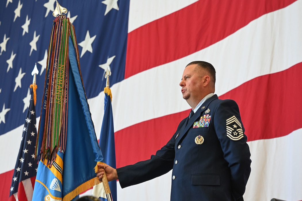 Chief Master Sgt. Cameron Davis, 314th Airlift Wing command chief, stands at parade rest with the wing guidon during a change of command ceremony