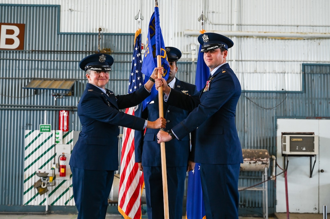 Airmen hold guidon.