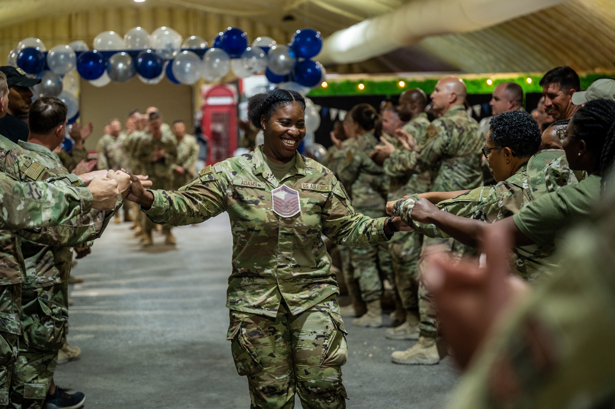 Technical Sgt. Talisha Adams, 332d Air Expeditionary Wing inspector general self-assessment program manager, walks toward the stage receiving congratulatory fist bumps from fellow Red Tails at the 332d Air Expeditionary Wing master sergeant release party June 1, 2022, at an undisclosed location in Southwest Asia. This year, the active duty Air Force selected 4,040 of 27,296 eligible technical sergeants for the promotion to master sergeant, at a selection rate of 14.8%. (U.S. Air Force photo by Master Sgt. Christopher Parr)