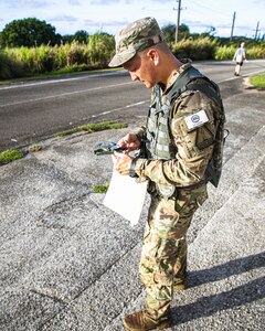 U.S. Army Staff Sgt. Jackson Fagan, representing the Utah Army National Guard Recruiting and Retention Battalion, orients himself using a compass for the land-navigation event during the Region VII Best Warrior Competition on the island of Guam